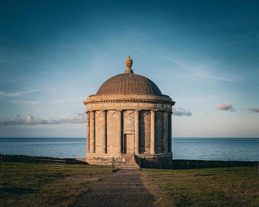 pexels-photo-28086731-28086731 Historic Temple of Mussenden set against the ocean, captured at sunset with a clear sky.